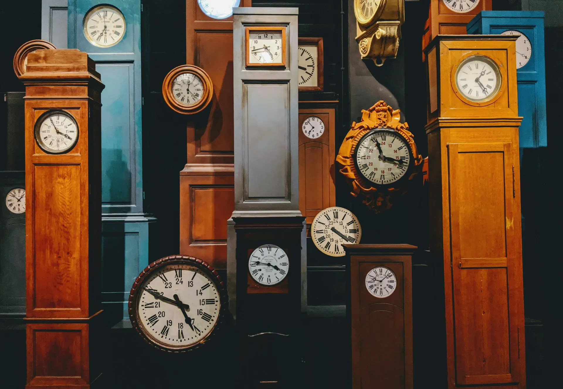 Lots of vintage clocks against a wall