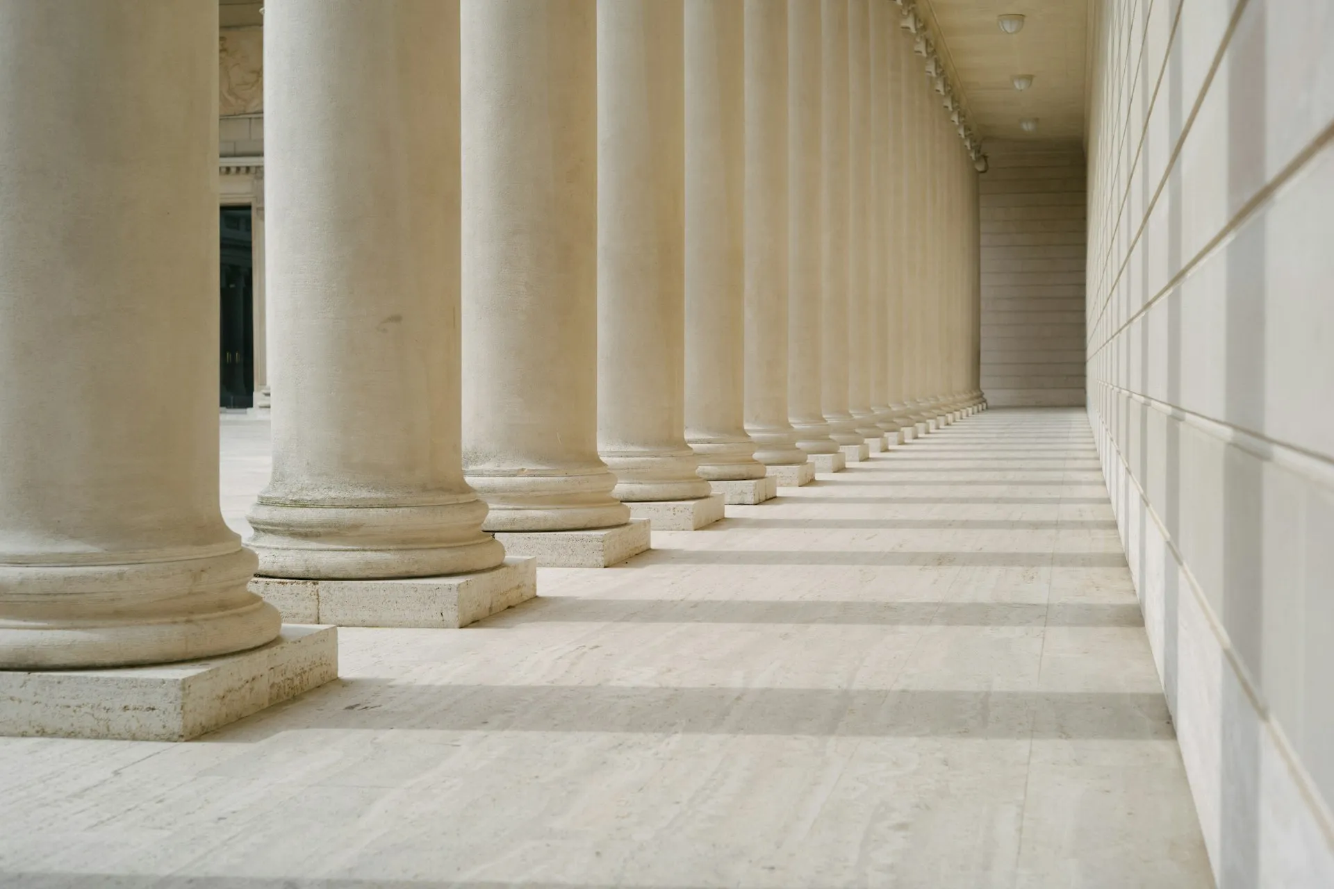 A series of white columns each casting a perfectly horizontal shadow