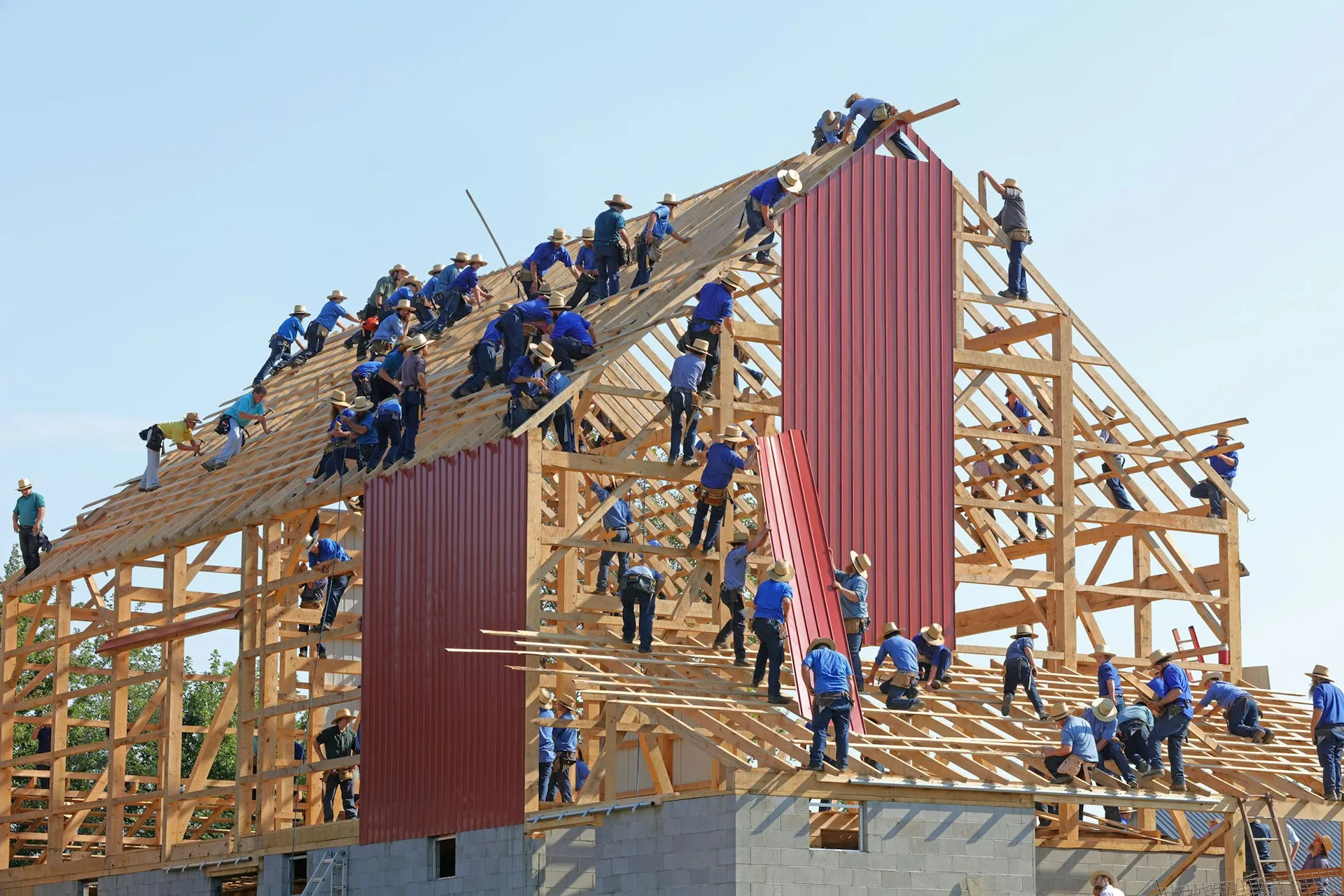 A house being constructed by a large number of people in uniform